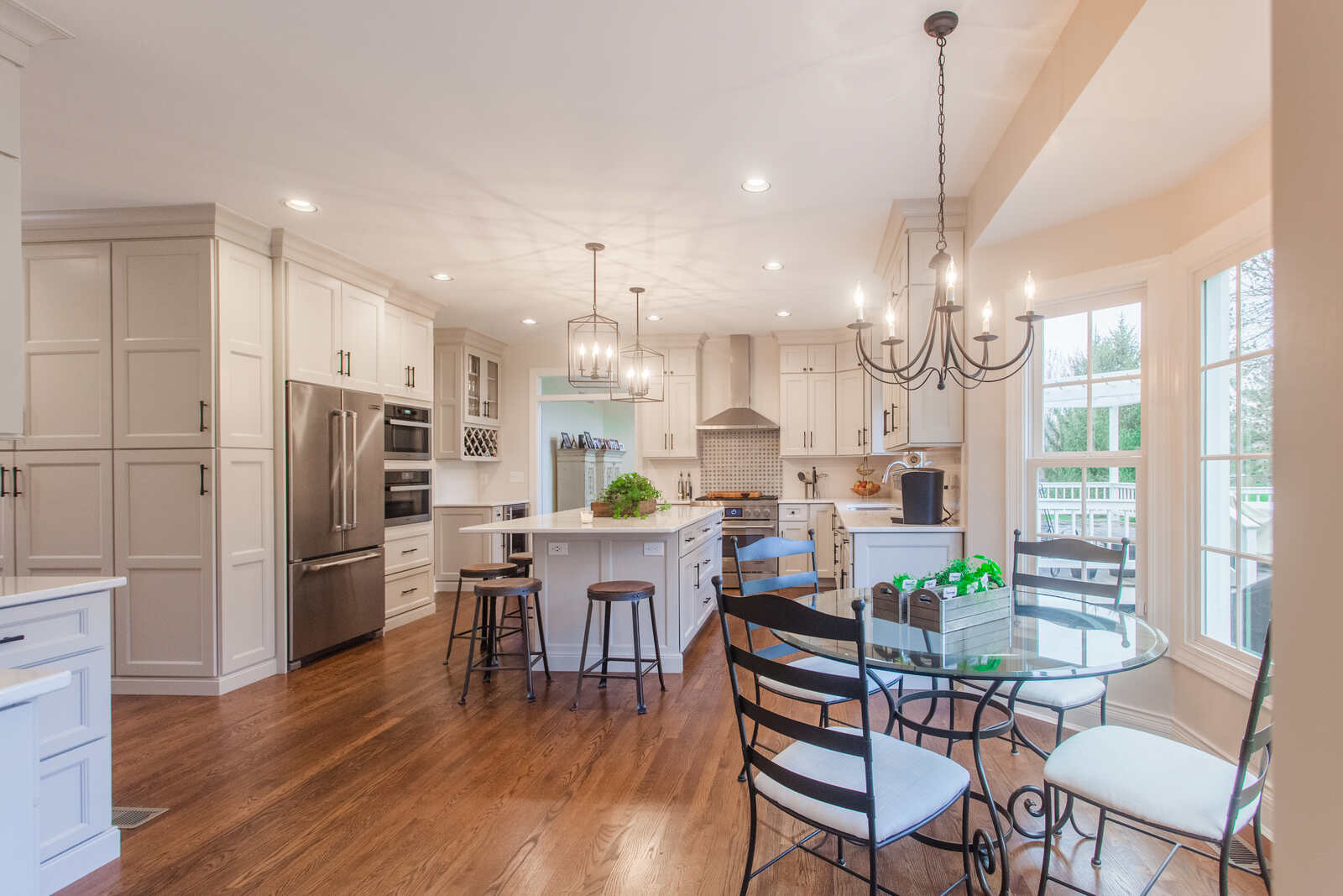 white kitchen with circular dinner table and bar stools at island